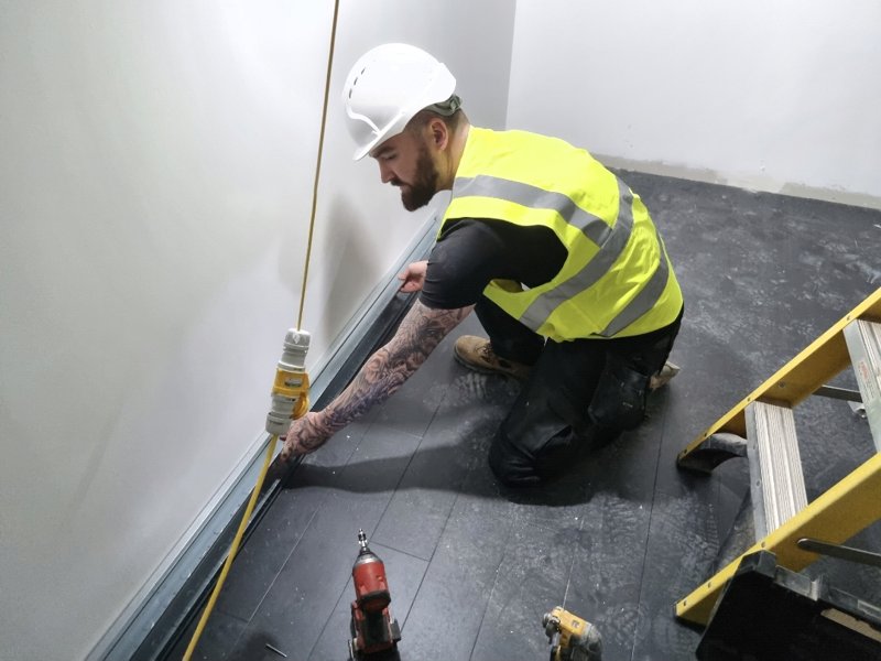 Chris from MHM Electrical in hard hat and hi-vis working on a commercial site
