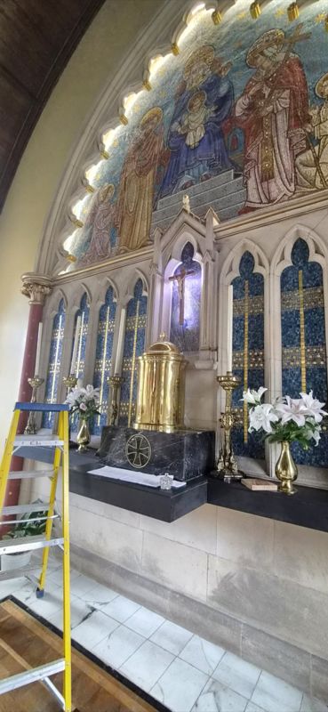 Lighting installed by MHM Electrical along a church arch and behind the crucifix